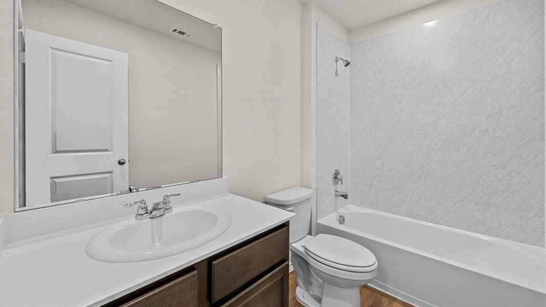 Bathroom with vanity, shower / bathtub combination, and wood finished floors
