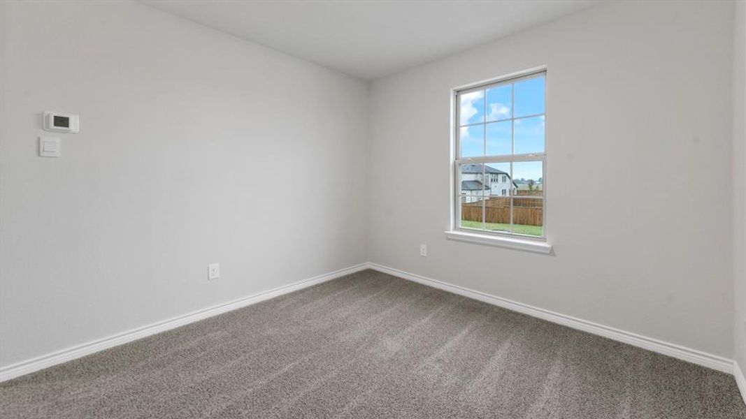 Carpeted room with a double-hung window
