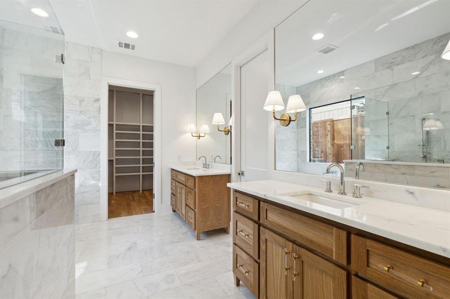 Bathroom featuring tiled shower and vanity