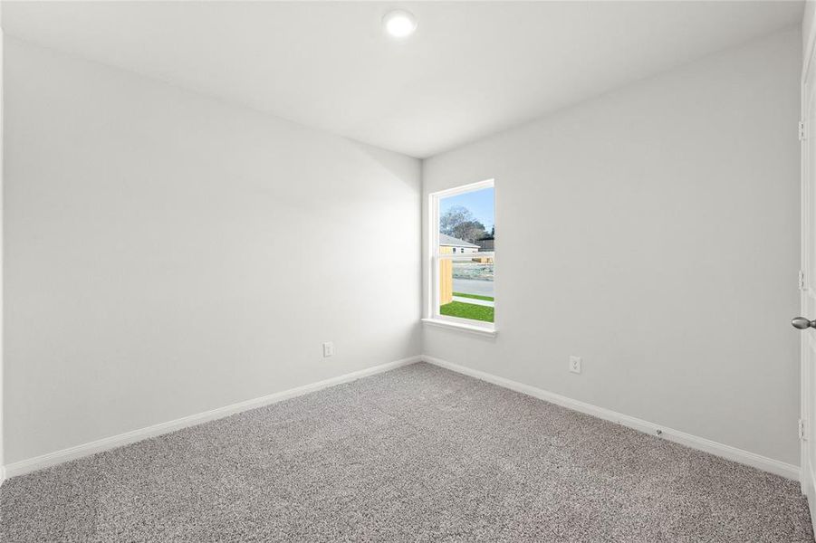 Empty room featuring carpet flooring and baseboards
