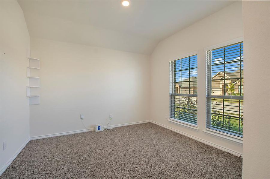 Empty room featuring carpet and vaulted ceiling