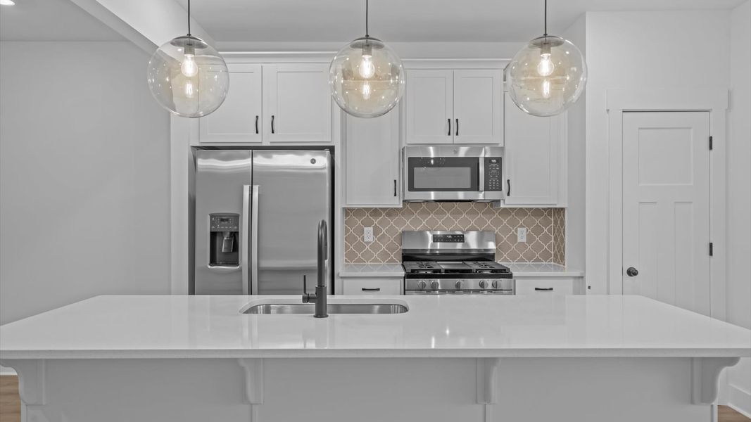 First-class kitchen with a spacious 9-foot island perfect for entertaining beneath designer pendant lighting First-class kitchen with a spacious 9-foot island perfect for entertaining beneath designer pendant lighting