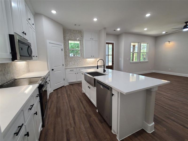 Kitchen featuring a kitchen island with sink, stainless steel appliances, sink, and a wealth of natural light