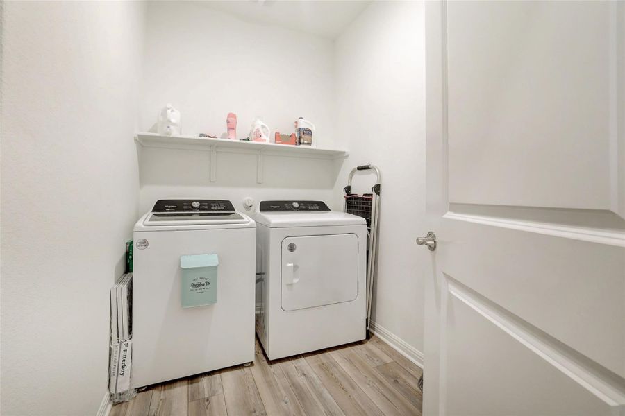 Washroom with washer and clothes dryer and light wood-style floors