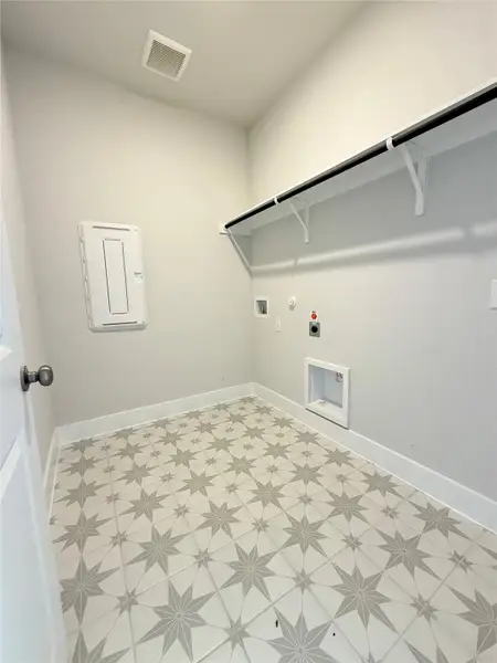 Laundry area with laundry area, light floors, hookup for an electric dryer, and visible vents