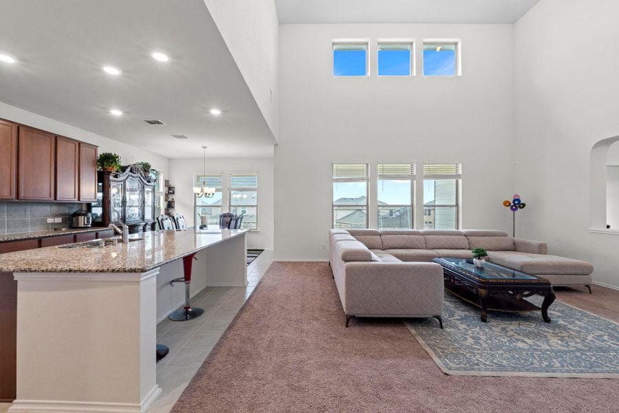 Vaulted living space featuring high ceilings, upper and lower windows, and an arched interior opening