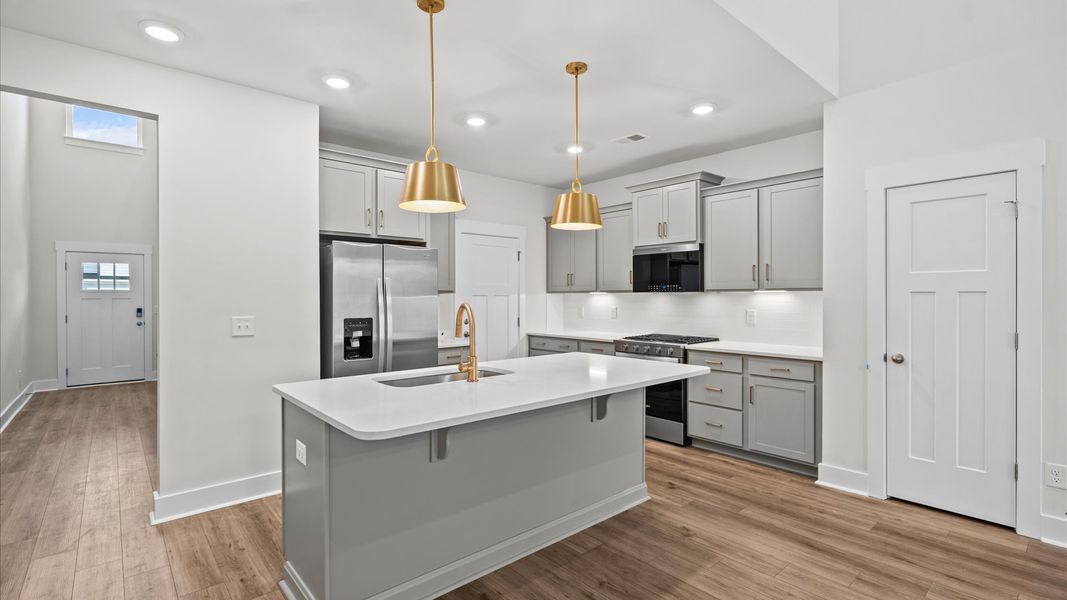 Tasteful kitchen with oversized island and stylish pendant lighting at Silo Ridge by DRB Homes in Anderson, SC