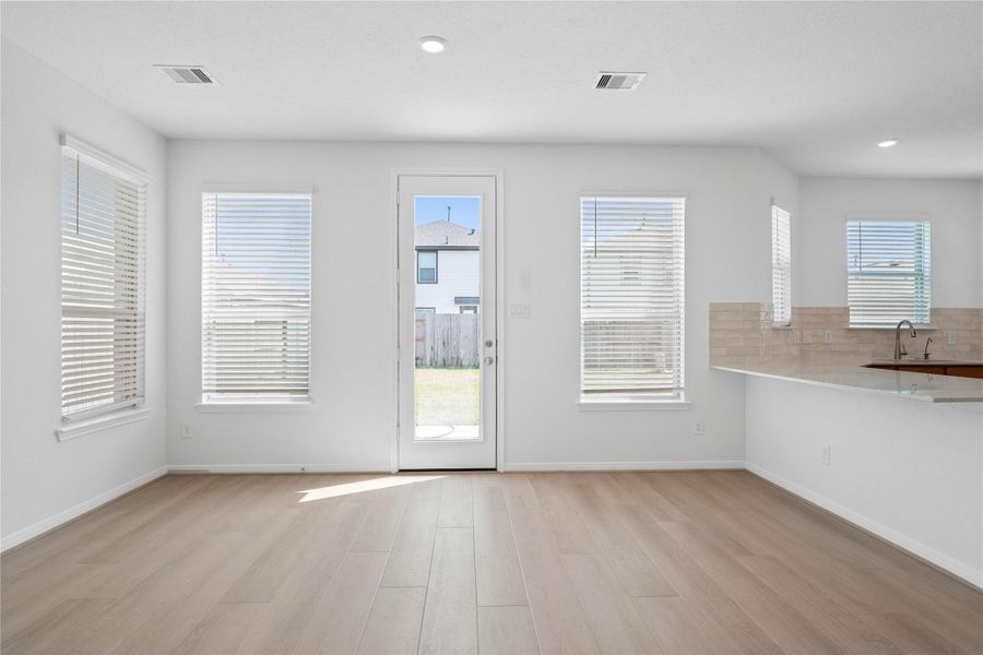 Start your day off right with a cup of coffee sitting with your family in the lovely breakfast area! Featuring large windows with blinds, custom neutral paint, vinyl plank flooring, high ceilings with recessed lighting and access door to the back patio and yard. Start your day off right with a cup of coffee sitting with your family in the lovely breakfast area! Featuring large windows with blinds, custom neutral paint, vinyl plank flooring, high ceilings with recessed lighting and access door to the back patio and yard.