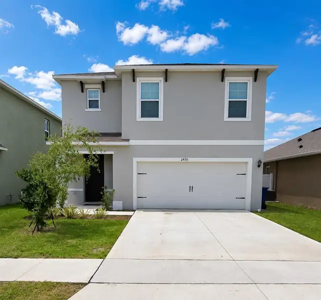 Front exterior of a new home in Eagle Hammock, Eagle Lake, FL, highlighting curb appeal (Image 1). Front exterior of a new home in Eagle Hammock, Eagle Lake, FL, highlighting curb appeal (Image 1).