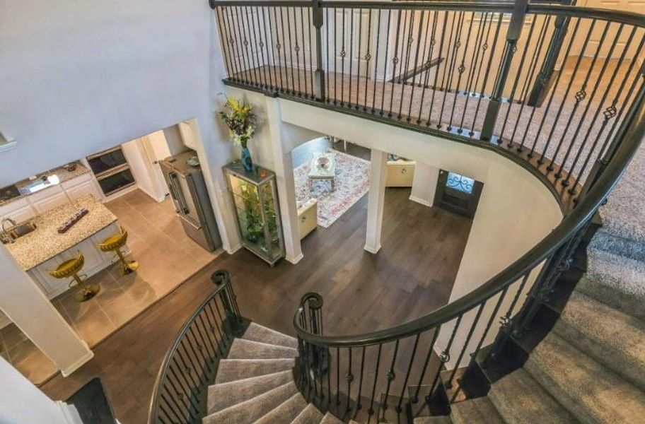 Stairway featuring a towering ceiling and wood-type flooring