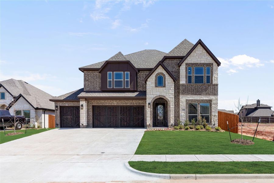 Two-story home with brick and stone exterior, three-car garage, and arched front entry Two-story home with brick and stone exterior, three-car garage, and arched front entry