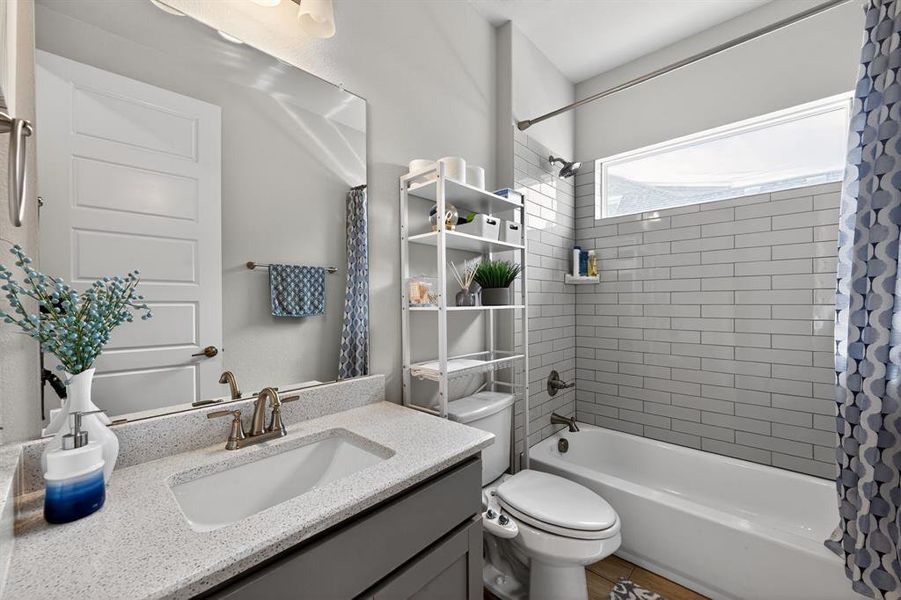 Bathroom featuring a single vanity with a light-colored countertop, an integrated sink, and brushed nickel fixtures