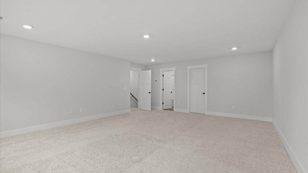 Notable secondary bedroom offering cozy carpeted flooring and a stylish walk-in closet