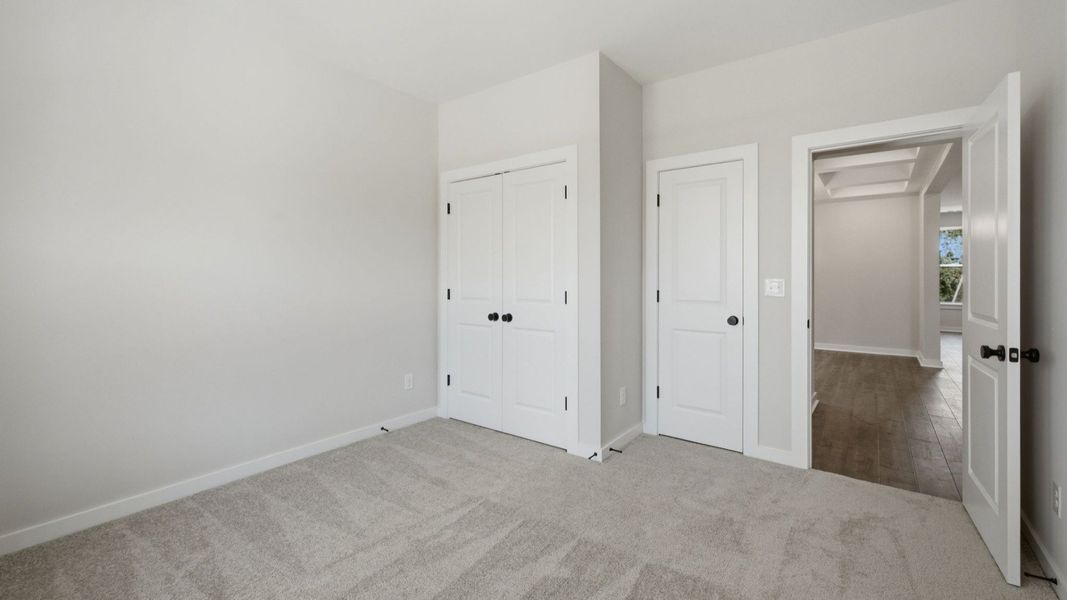 Secondary bedroom with carpet and spacious double closets