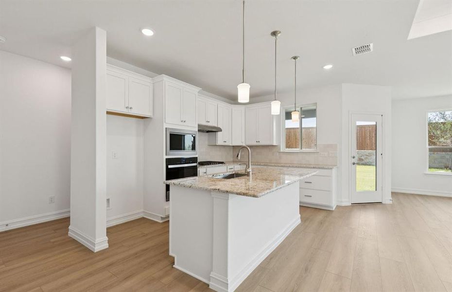 Bright kitchen with an expansive center island perfect for gatherings  *Real home pictured