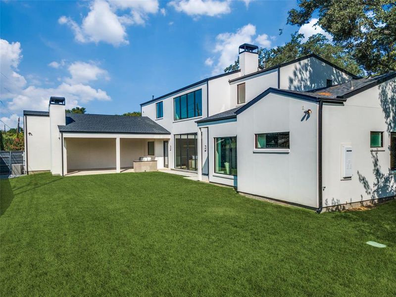 Rear view of property with a lawn