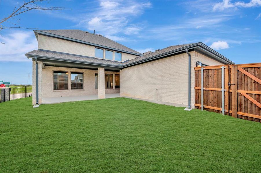 Back of house featuring a fenced backyard, a patio, a gate, brick siding, and roof with shingles
