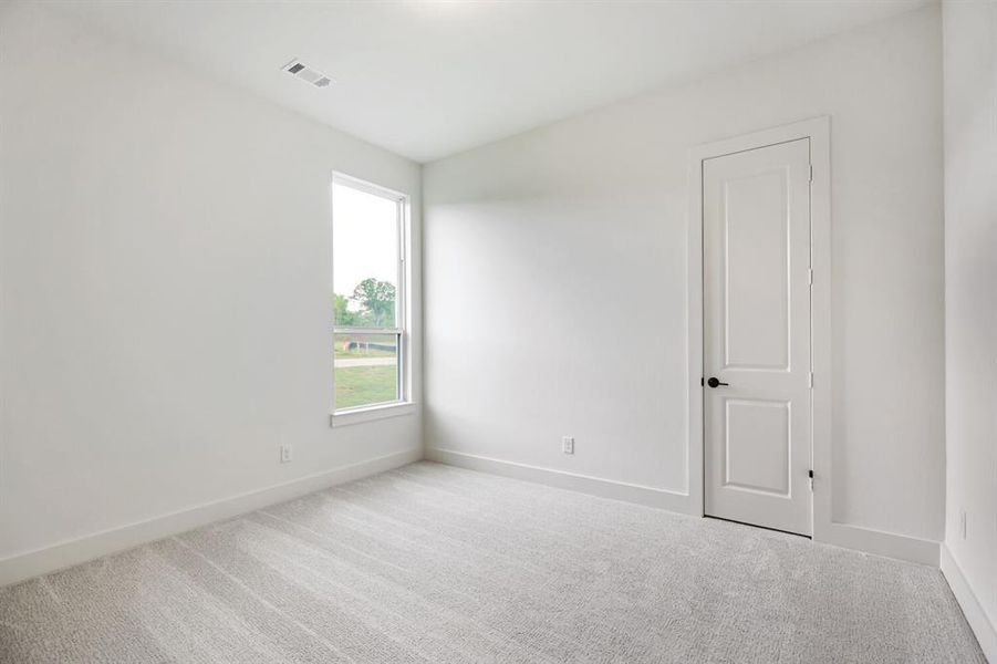 Spare room with light colored carpet and baseboards