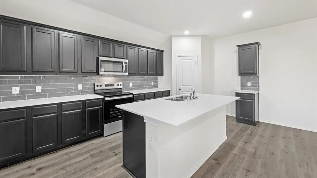 Kitchen featuring dark wood-finish cabinetry, light countertops, subway tile backsplash, and wood-finish flooring