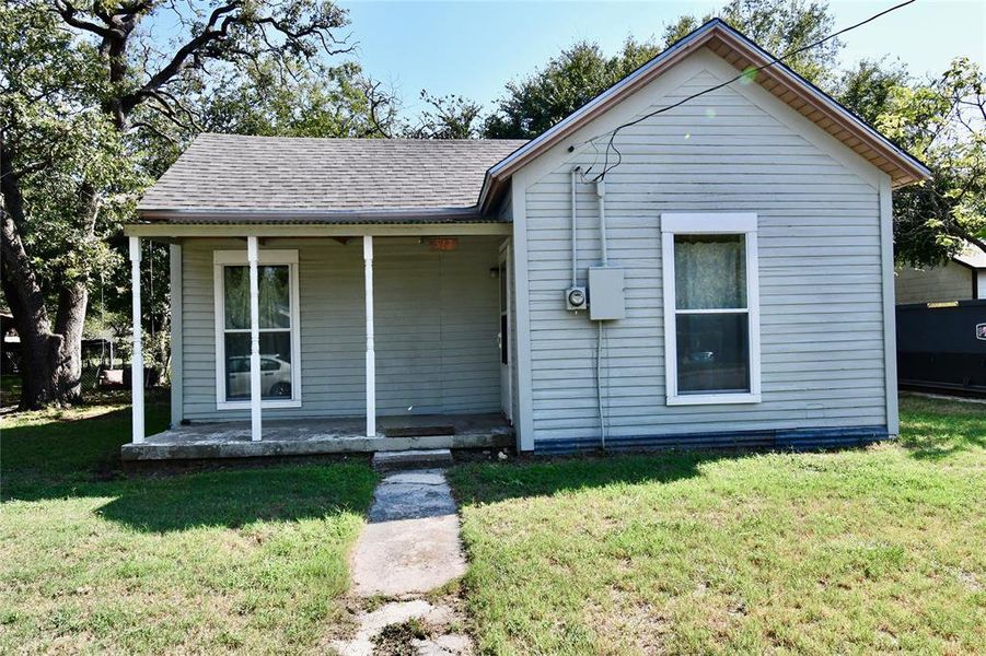 Bungalow-style house with covered porch, a shingled roof, and a front yard Bungalow-style house with covered porch, a shingled roof, and a front yard