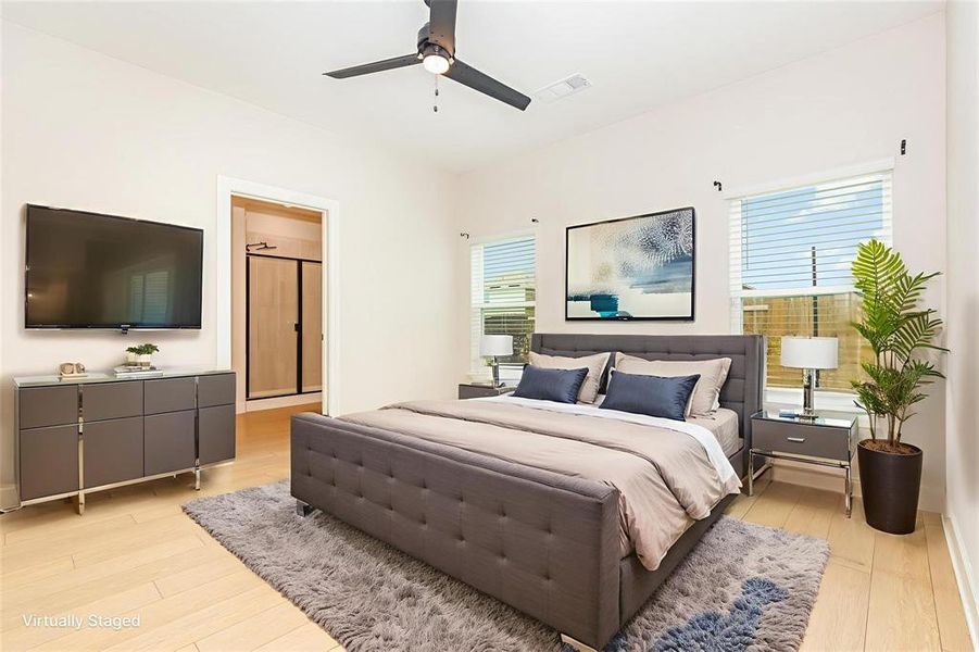 Bedroom with light wood-style flooring and a ceiling fan Bedroom with light wood-style flooring and a ceiling fan