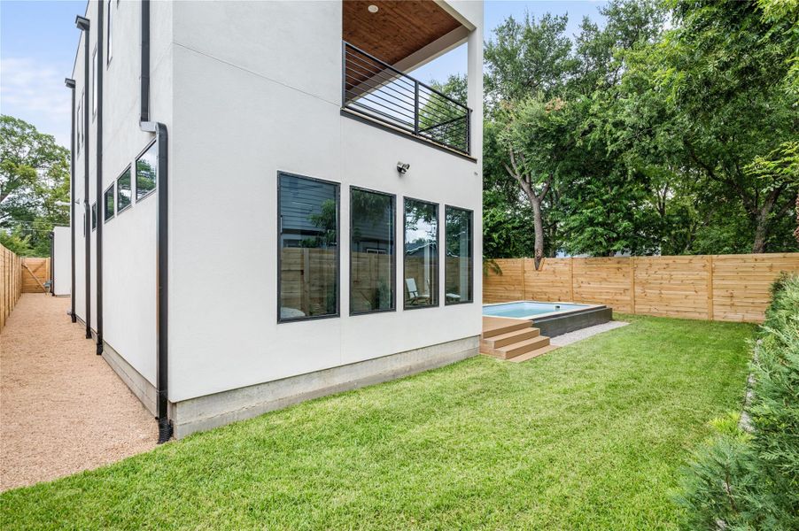 A private backyard oasis features a modern plunge pool with sleek wooden steps, bordered by a new privacy fence and mature trees. A private backyard oasis features a modern plunge pool with sleek wooden steps, bordered by a new privacy fence and mature trees.