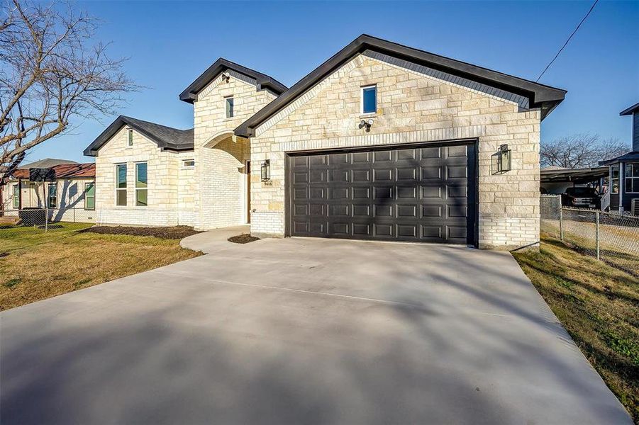 View of front of home featuring a front yard and a garage