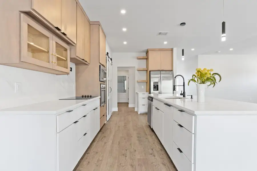 Kitchen featuring open shelves, hanging light fixtures, light stone counters, recessed lighting, and light wood finished floors