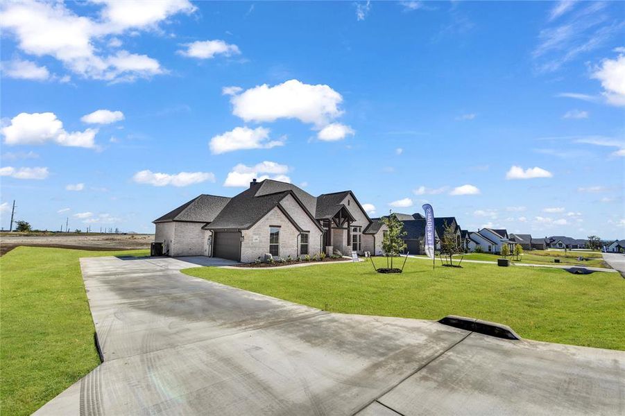 French provincial home featuring a front yard and a garage