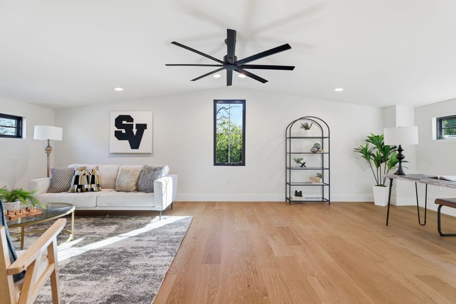 Living area with light wood finished floors, recessed lighting, vaulted ceiling, and ceiling fan