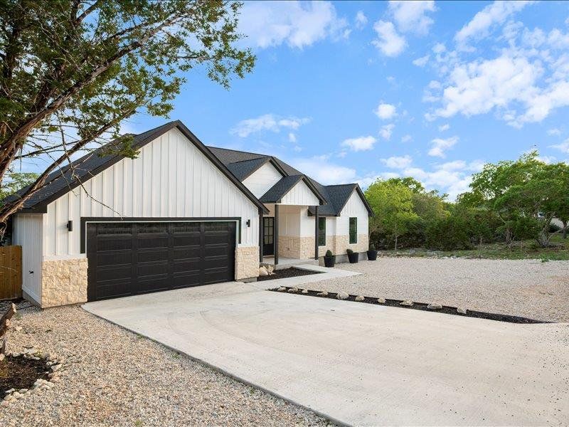 The property features a concrete driveway leading to a two-car garage