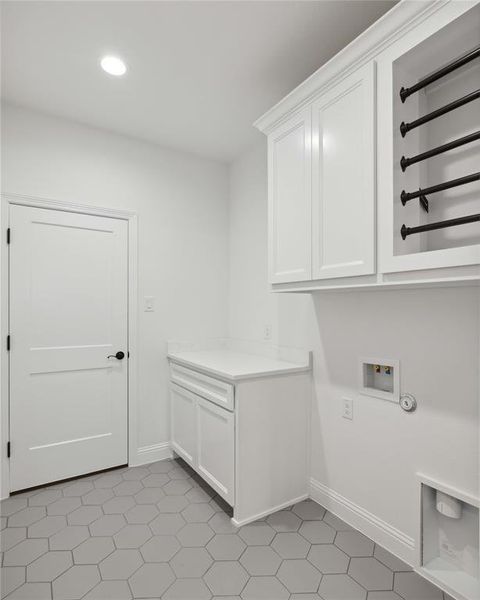 Laundry area with cabinets, hookup for a washing machine, and light tile patterned floors