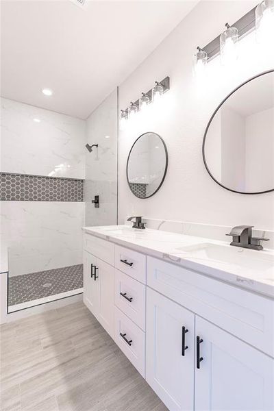 Bathroom with dual vanity and tiled shower