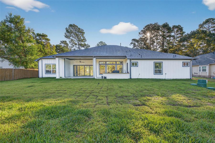 Rear exterior view highlights the expansive backyard and broad covered outdoor living area. **Images are from a previously completed project. **