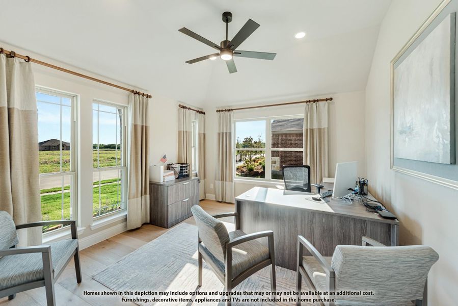 Home office with wood desk, ceiling fan, vaulted ceiling, and large windows with neutral curtains Home office with wood desk, ceiling fan, vaulted ceiling, and large windows with neutral curtains