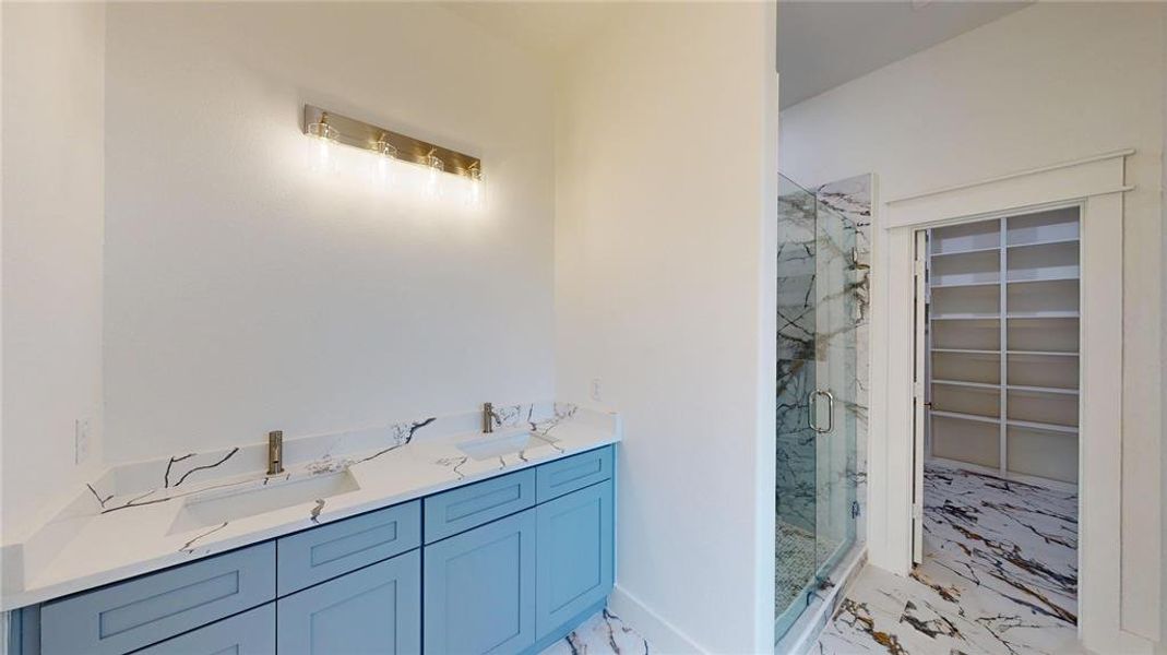 Bathroom with a sink, marble finish floor, and a marble finish shower