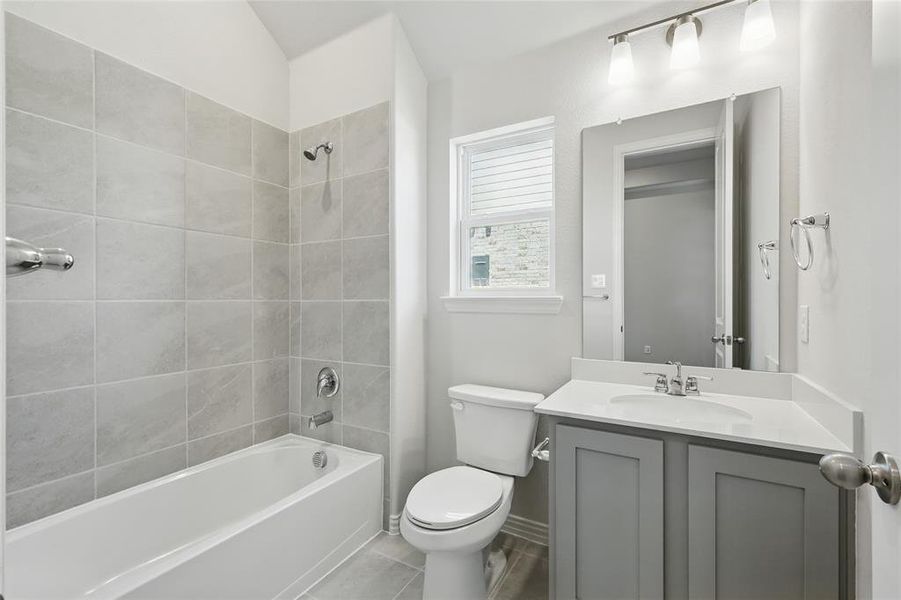 Full bath featuring vanity, bathing tub / shower combination, and tile patterned flooring Full bath featuring vanity, bathing tub / shower combination, and tile patterned flooring