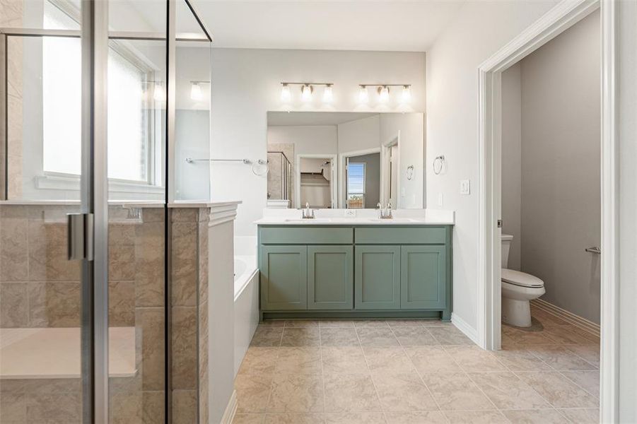 Full bathroom with a garden tub, a shower stall, double vanity, and light tile patterned floors Full bathroom with a garden tub, a shower stall, double vanity, and light tile patterned floors