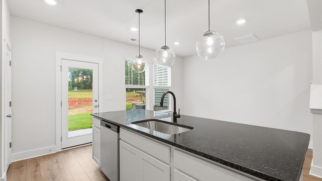 Open-concept kitchen designed to maximize both efficiency and entertaining potential by DRB Homes