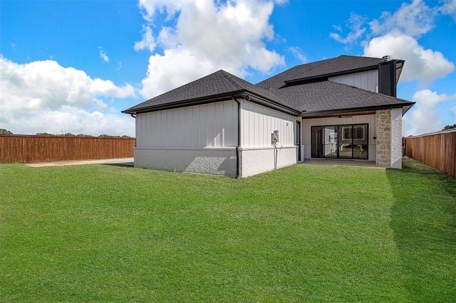 Back of house featuring a shingled roof, a patio area, and a fenced backyard Back of house featuring a shingled roof, a patio area, and a fenced backyard