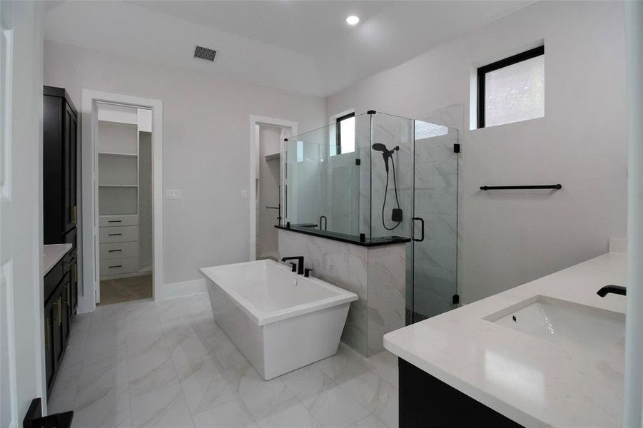 Bathroom with plenty of natural light, vanity, and plus walk in shower