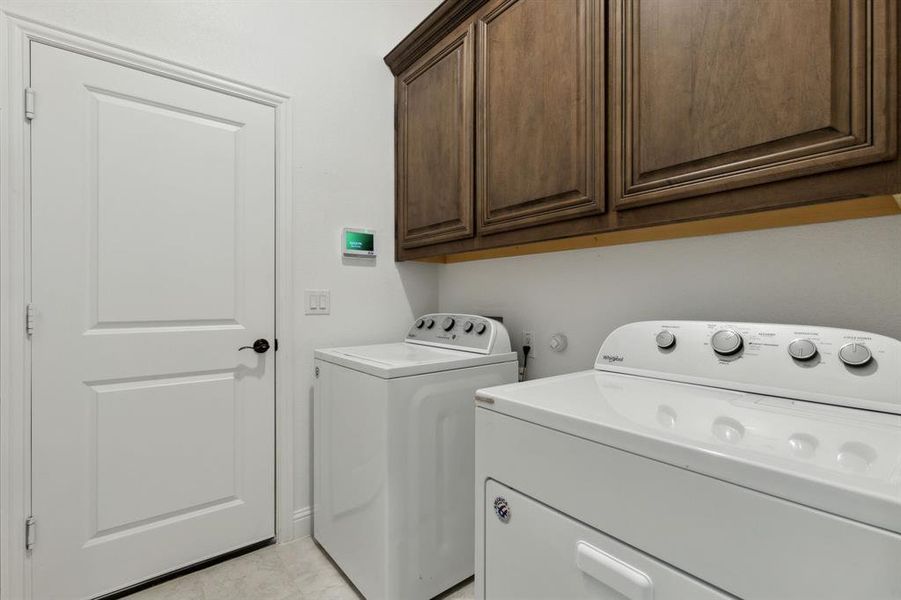 Laundry room with built in cabinets for additional storage.  The washer and dryer willl convey.