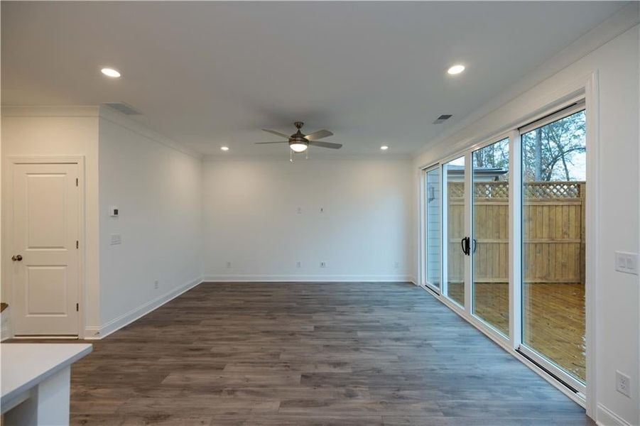 Spare room with dark hardwood / wood-style flooring, ceiling fan, and ornamental molding