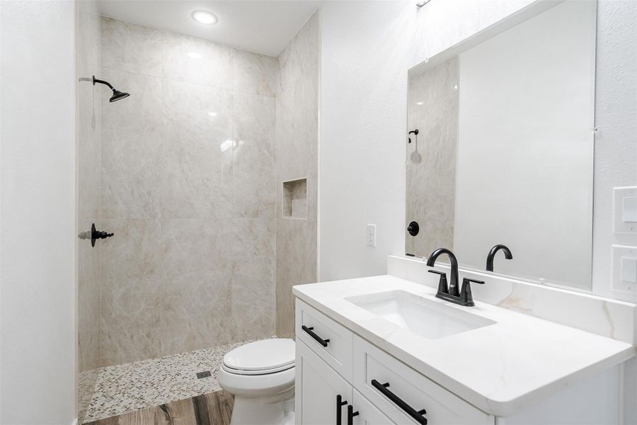 A sleek, contemporary bathroom features a spacious walk-in shower and modern vanity. A sleek, contemporary bathroom features a spacious walk-in shower and modern vanity.