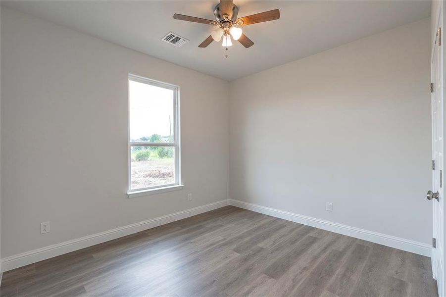 Unfurnished room with hardwood / wood-style flooring and ceiling fan