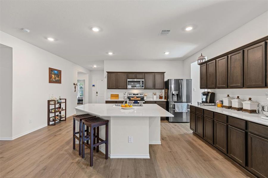 Open concept kitchen with large center island, quartz countertops, stainless steel appliances, and abundant cabinet space. Open concept kitchen with large center island, quartz countertops, stainless steel appliances, and abundant cabinet space.