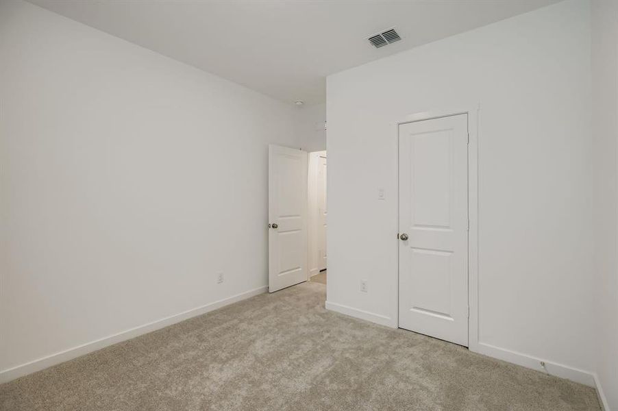 Unfurnished bedroom featuring light carpet and baseboards