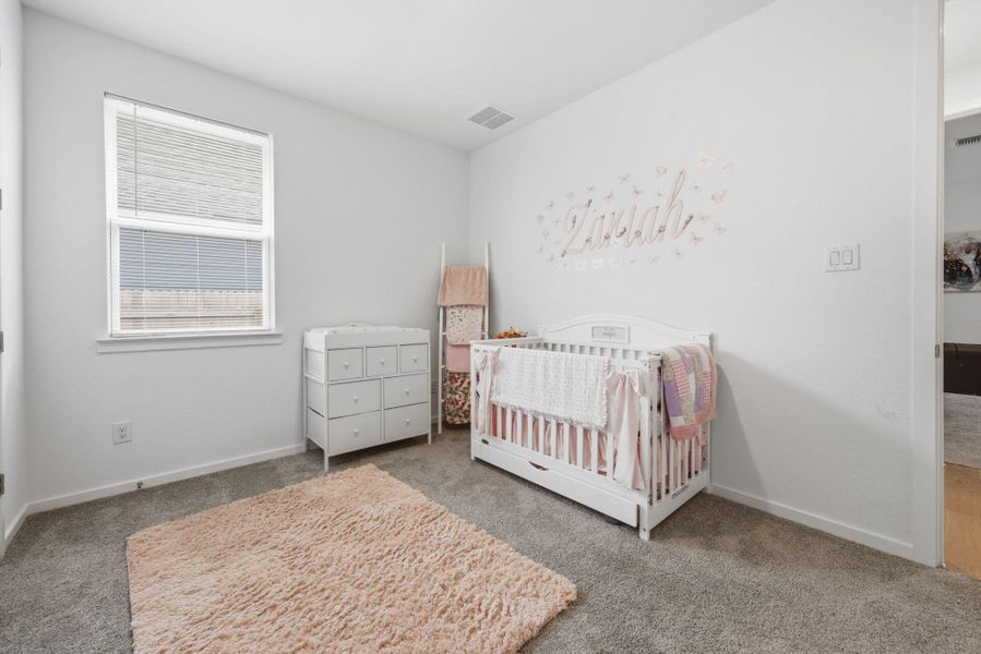 Bedroom with carpet and a nursery area