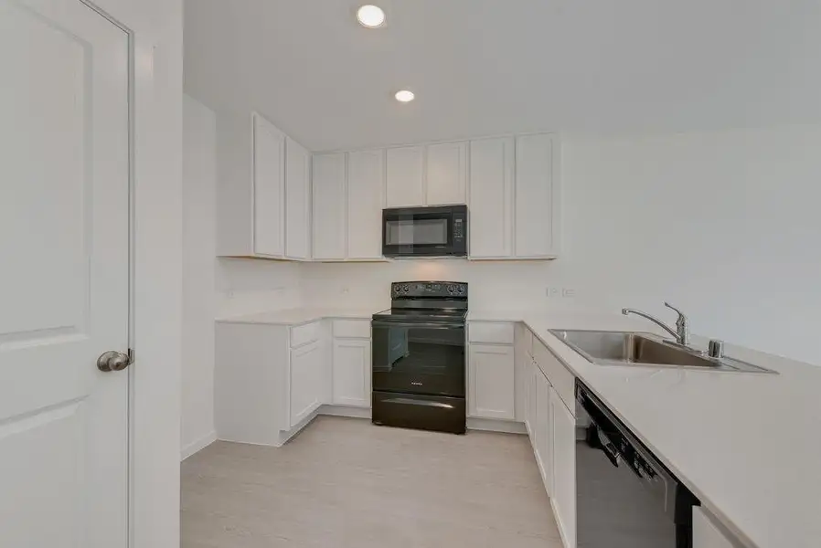 Kitchen featuring black appliances, white cabinetry, recessed lighting, and light wood-type flooring
