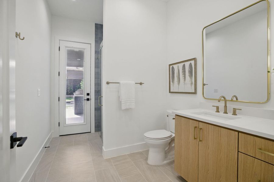 Bathroom with baseboards, vanity, toilet, a shower stall, and tile patterned flooring